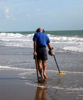 Man Metal Detecting On Beach